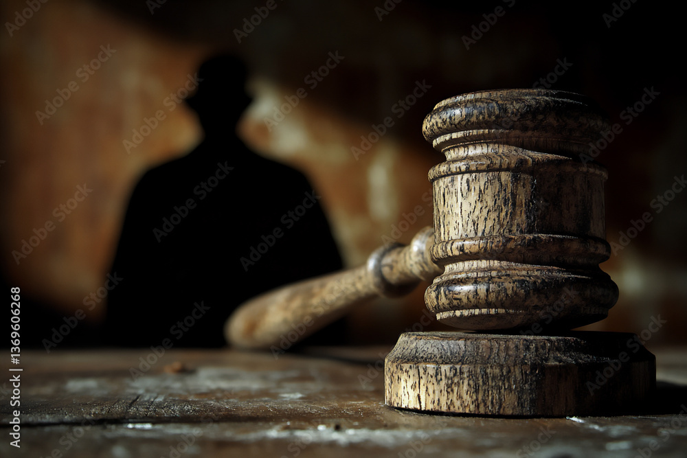 Poster a gavel with a shadow casting a silhouette of a judge or figure of authority.