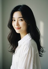 Soft light illuminates a woman smiling gently in a white shirt classic portrait photography. AI Generated