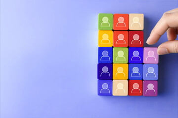 Business team and recruitment concept. A hand placing a wooden figure within a group