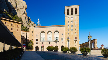 Fachada de la bas&iacute;lica de Montserrat iluminada al amanecer, con cielo despejado en Catalu&ntilde;a, Espa&ntilde;a.