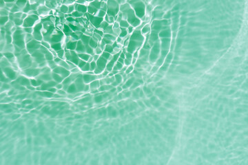 Blue water with ripples on the surface. Defocus blurred transparent blue colored clear calm water surface texture with splashes and bubbles. Water waves with shining pattern texture background.