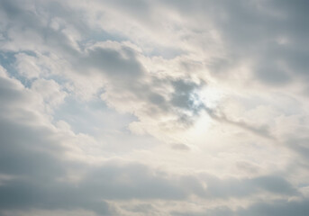 Obraz premium A sky filled with soft clouds where the sun's gentle glow creates a serene vista.