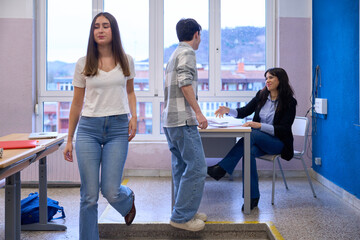Students delivering homework to teacher in institute classroom