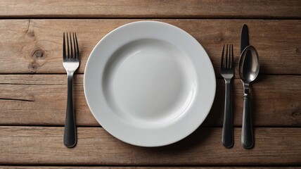 A minimalist dining setting featuring a plain white plate surrounded by silver cutlery on a rustic wooden table.