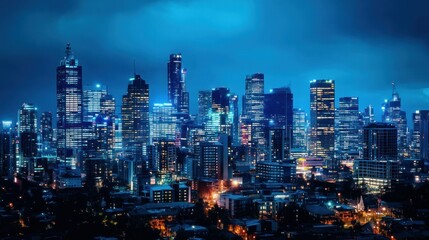 Fototapeta premium A panoramic skyline view with skyscrapers illuminated against the night sky.