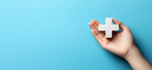 A hand is gripping a striking red cross symbol set against a blue background