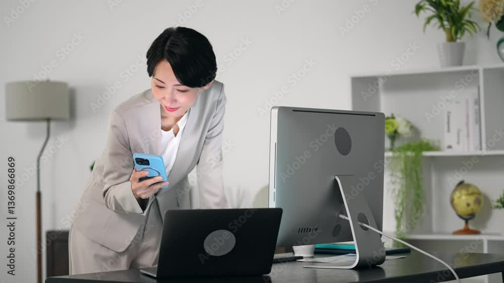 Aufkleber 暗いオフィスでスマホとパソコンを使って作業する女性ビジネスパーソン