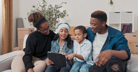 On the couch in their new home, the family scrolls through ideas on a tablet. The kids pick...
