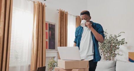 Buying furniture online happy smiling man clicks on laptop standing on cardboard boxes boy has...