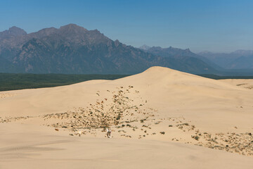 Chara sands and Kodar mountain range. Siberian desert surrounded by mountains. Summer natural unusual landscape.