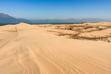 Chara sands and Kodar mountain range. Siberian desert surrounded by mountains. Summer natural unusual landscape.
