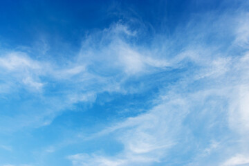 Bright blue sky with soft white clouds background