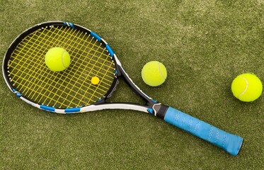 A tennis racket and new tennis ball on a freshly painted tennis court