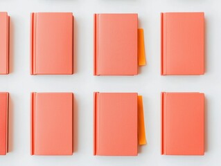 Arranged Coral Notebooks with Bookmark on White Background