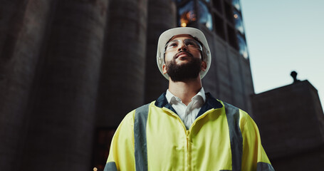Man, engineer and thinking in city with helmet for urban expansion, construction and low angle by...