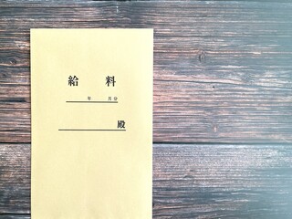 木製机に置いた給料袋