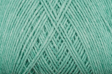 A close-up texture shot of green yarn with diagonal stripes