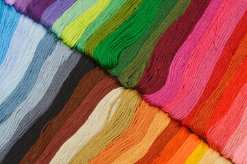 Rows of colorful embroidery floss in warm earth and cool blue tones
