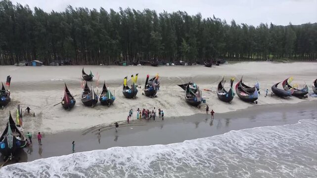 A drone shot of strangely shaped boats called moonboats lining the coast of Cox's Bazar, Bangladesh.