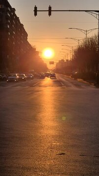 Sun setting over Iuliu Maniu Boulevard in Bucharest with traffic and long shadows