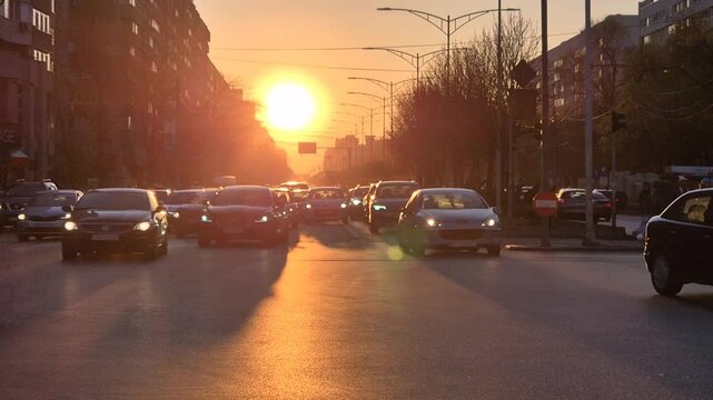 Sun setting over Iuliu Maniu Boulevard in Bucharest with traffic and long shadows