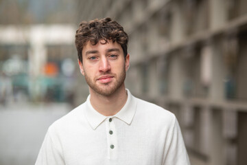 Portrait of confident young man posing in urban setting with blurred background