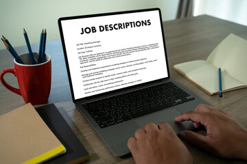 The businesswoman used her laptop to fill out the job application, reviewing the contract and...