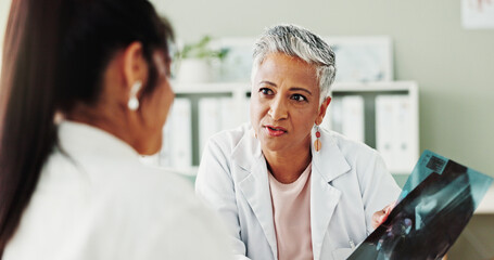 Obraz premium Appointment, checkup or radiology with doctor and patient in office of hospital for consulting. Conversation, medical or x ray with mature medicine professional and woman in clinic for treatment