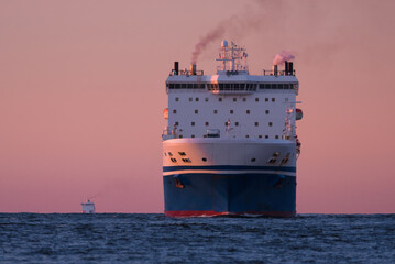 MARITIME TRANSPORT - Passenger/Ro-Ro Cargo Ship sails on the sea at sunset
