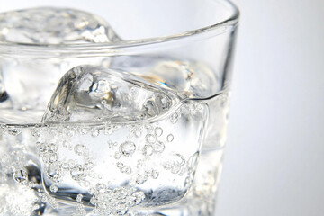 Close-up view of a glass filled with refreshing water and ice cubes with subtle condensation forming