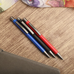 Colorful Assorted Pens Arranged Neatly on a Textured Surface