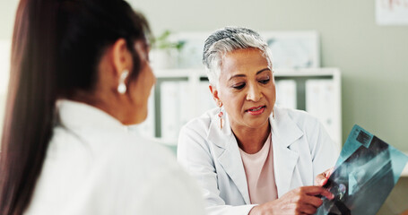 Obraz premium Healthcare, results or x ray with doctor and patient in office of hospital for consulting. Diagnosis, pointing or radiology with mature medicine professional and woman in clinic for medical feedback