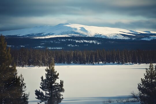 Snowy landscape with mountains and a frozen lake under cloudy sky - Powered by Adobe
