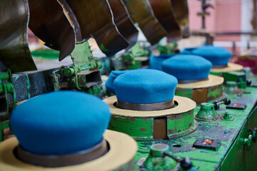 Crafting blue berets in a traditional felt factory showcasing skilled craftsmanship and vibrant materials