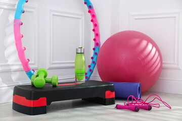 Different fitness equipment near white wall indoors