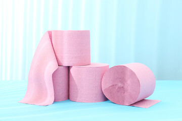 Pink toilet paper rolls on light blue background