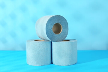 Light blue toilet paper rolls on color background