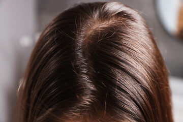 Woman with healthy hair roots on blurred background, closeup
