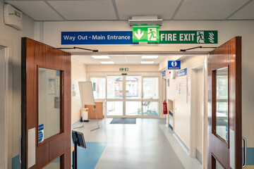 Shallow focus of a typical illuminated Fire Exit sign seen within an NHS hospital outpatients...