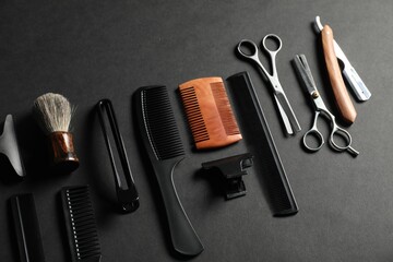 Many different barber's tools on black table, above view