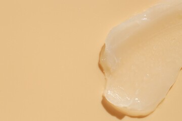Moisturizing lip balm on beige background, top view. Space for text