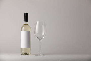 Tasty wine in glass and bottle on light grey background, space for text