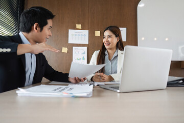 Engaging Discussion and Productive Conversations. Two colleagues share insights and strategies while discussing essential documents at work.