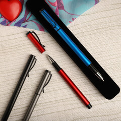 Elegant Pen Standing on Open Notebook with Vivid Decorative Backdrop, concept idea photo. Study desk image, top view.
