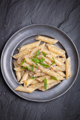 Penne with ground pepper and Gorgonzola creamy sauce, sprinkle with chopped chives.