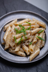 Penne with ground pepper and Gorgonzola creamy sauce, sprinkle with chopped chives.