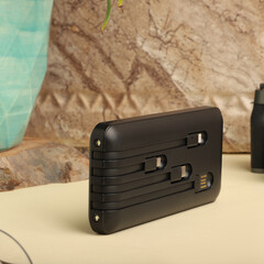 Compact Multi-Port Mobile Charger With Integrated Cable Storage, concept photo shoot.