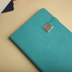 Stylish black notebooks with colorful bands and pen on desk