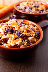 Colorful vegan cous cous with chickpeas, purple cabbage and carrots. Topping of tahini and flax seeds.