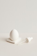 Minimalist Easter Concept with White Egg, Gauze and Medical Dropper